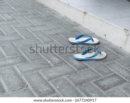 A Pair of Wornout Flipflops Left Behind on a Dusty Pavement, a Tale of Transient Journeys