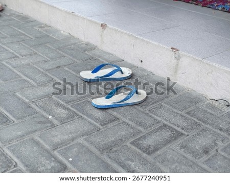 A Pair of Wornout Flipflops Left Behind on a Dusty Pavement, a Tale of Transient Journeys
