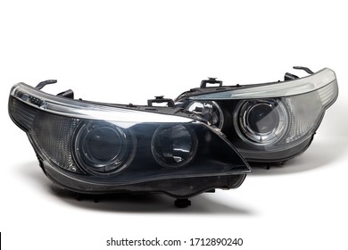 A pair of xenon headlights for a German auto - optical equipment with a lens and corrector inside on a white isolated background. Spare part for replacing a front body part in a car service. - Shutterstock ID 1712890240