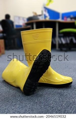 A pair of yellow boots made of rubber used by workers, for gardening and all activities in wet places to protect feet from dirt and harmful chemical splashes and splashes of water