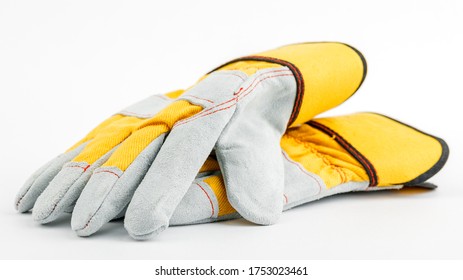 pair of yellow construction gloves on a white insulated background.