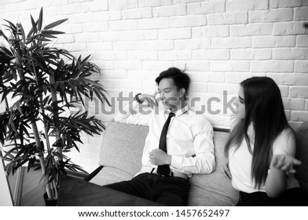 A pair of young people talking at the office table
