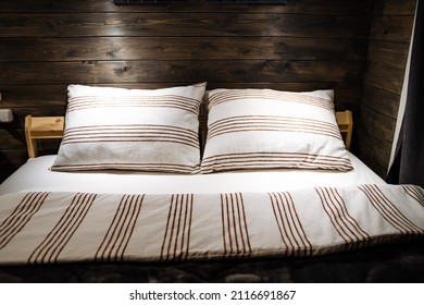 Paired pillows made of soft fabric with a geometric pattern. Cozy wooden room,Deep sleep. The dim light in the wood room. Cotton bed linen. High quality photo