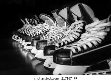 Pairs of hockey skates lined up in a locker room