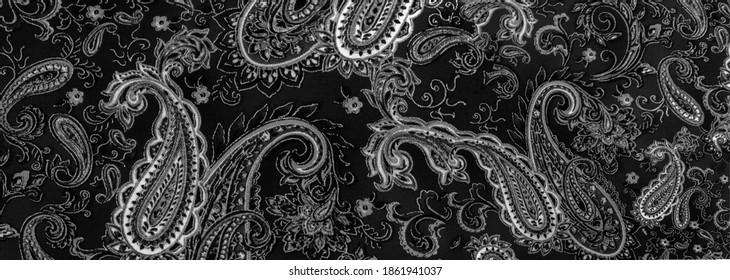 Paisley black-white pattern on a black background. decorated the bandanas of cowboys and bikers popularized by The Beatles, ushered in the era of hippies and became the emblem of rock and roll.