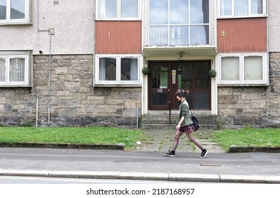 Paisley, Scotland, UK, August 2nd 2022, Student Walking Past Council Flats In Poor Housing Estate With Many Social Welfare Problems