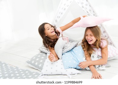 Pajamas party for kids. Girls having fun tipi house. Girlish leisure. Sisters share gossips having fun at home. Cozy place tipi house. Sisters or best friends spend time together lay in tipi house.