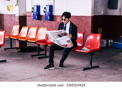 Pak Kret, Nonthaburi, Thailand - On 23 October 2018 - The Young Man Sat To Read The Newspaper While Waiting For The Train.