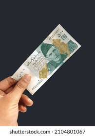 Pakistan 500 Money Holding With Hand. Black Background. 