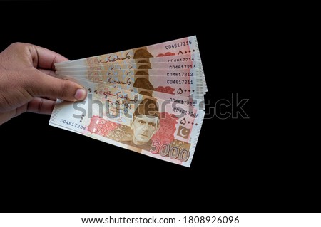 Pakistani 5000 Note hold in hand, Isolated on black background