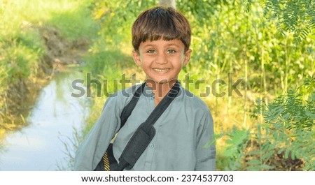 A Pakistani baby boy stylish posing against natural field. Pakistani model baby boy doing stylish poses. Pakistani village baby boy in cultural dress. Portrait of Asian model baby boy. Happy face.