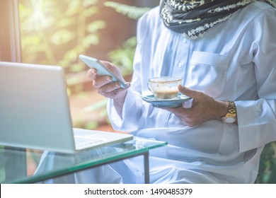 Pakistani business asian man using smart mobile phone, wear muslim dress sit in coffee shop,freelance business concept.