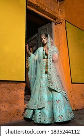 Pakistani Indian bride wearing wedding lehenga sharara design and jewelry. Outdoor fashion with Indian Bride.