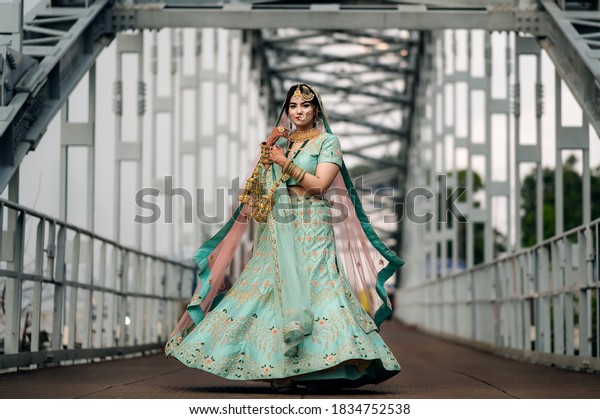 Pakistani Indian bride wearing wedding lehenga sharara design and jewelry. Outdoor fashion with Indian Bride.Moving subject with motion blur and selective focus.