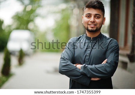 Сonfident pakistani indian muslim arabic boy in grey kameez shalwar suit.
