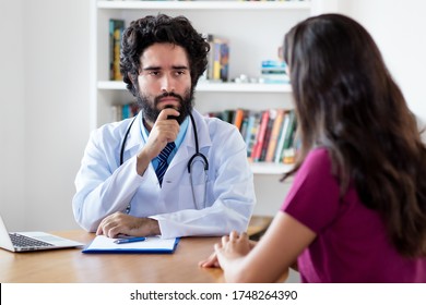 Pakistani Male Doctor Listening To Female Patient At Hospital