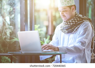 Pakistani Muslim Man Working On Laptop In Coffee Shop