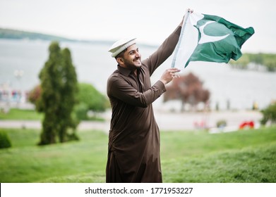 Pakistani Pathan Man Wear Traditional Clothes Hold Pakistan Flag.