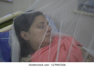 Pakistan-Lahore,A Girl Suffering From Dengue Fever Sits Under A Mosquito Net While Seeking Treatment At A Hospital In Lahore September 17, 2011. 