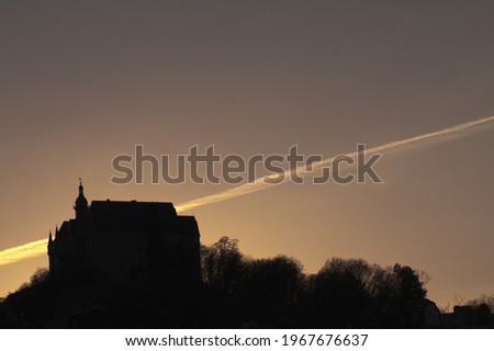 Palace on hilltop in sunset lighning with plane trail in the back