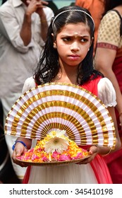 PALAKKAD, KERALA, INDIA, APRIL 30, 2015: A young girl holding a platter with a lamp, flowers and a frilled decorated piece of cloth welcoming the bridegroom for the wedding.