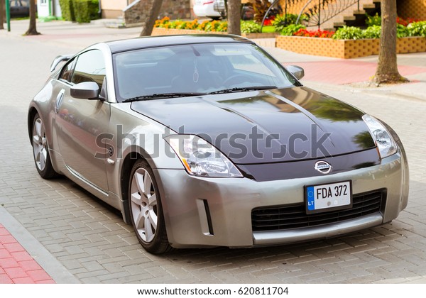 Palanga, Lithuania - August 13, 2012: Modern\
sports coupe car Nissan 350z parked on main transport highway in\
Lithuanian resort town Palanga. Youth high-tech sports car of\
Japanese production