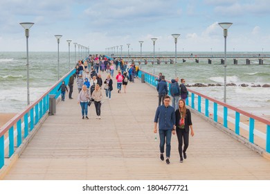 Palanga, Lithuania - August 28 2020: People are walking on a pier bridge. Cloudy day in a city Palanga