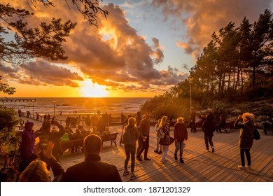 Palanga, Lithuania - July 12, 2020: Tourists are watching a sunset at a famous marine Palanga pier on the Baltic sea in the resort city Palanga.
