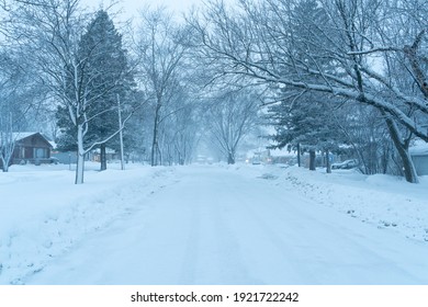 Palatine, IL - February 21 2021: A Residential Street In A Suburb Of Chicago Covered In Snow During A Snow Storm