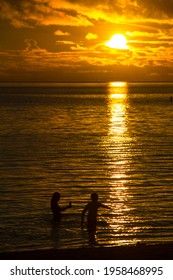 Palau - June 21, 2017: Silhouette Of A Family Playing In The Sea. While Waiting For The Sun To Set On The Beach Of The Palau Pacific Resort, Palikir, Micronesia