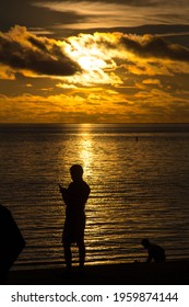 Palau - June 21 2017: Silhouette Of A Family Playing While Waiting For The Sunset On The Beach Of Palau Pacific Resort, Micronesia.