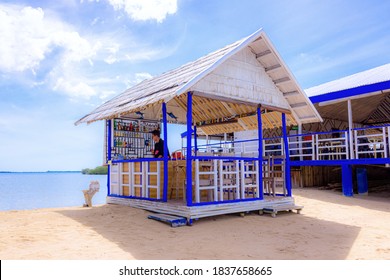 Palawan, Philippines - September 27, 2018: lone bartender behind the counter in an empty beach bar on a tropical island. Beach rest and relaxation.