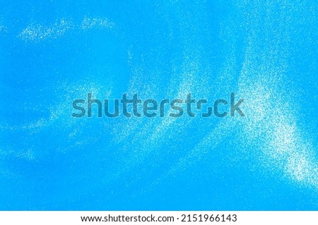 Pale blue liquid background with small pearlescent luminous particles. Cosmetic textured Blue flowing waves background with shiny streaks. 