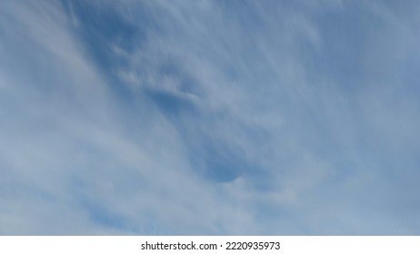 Pale blue sky with clouds. Autumn evening high in the sky are translucent white-gray cirrus clouds. They are blurry translucent through them you can see the pale blue sky. - Shutterstock ID 2220935973