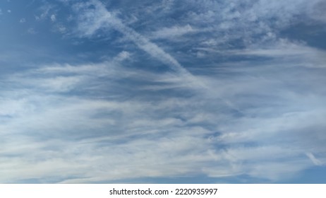 Pale blue sky with clouds. Autumn evening high in the sky are translucent white-gray cirrus clouds. They are blurry translucent through them you can see the pale blue sky. - Shutterstock ID 2220935997
