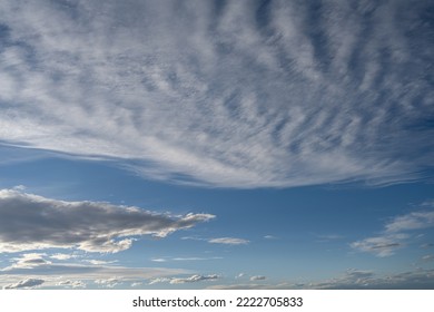 Pale Blue Sky With White To Light Grey Clouds. View Of Sky Only Starting At The Horizon.
