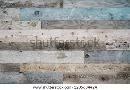 Pale faded brown and cool blue reclaimed wood surface with aged boards lined up. Wooden planks on a wall or floor with grain and texture. Neutral stained vintage wood background.