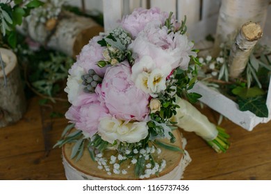 Pale pink colored peonies, freesias and greenery bouquet sitting on top of a rustic wooden table, floral arrangement for the bride, perfect accessory for wedding ceremony - Powered by Shutterstock