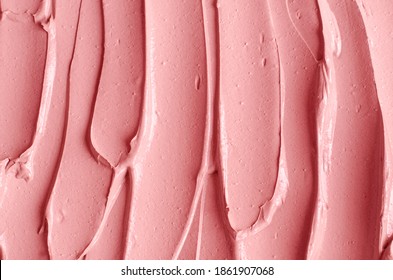 Pale pink cosmetic clay (alginate modeling facial mask, face cream, body wrap) texture close up, selective focus. Abstract background with brush strokes. 