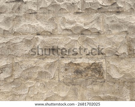 Pale Split-Face Stone Wall with Chiseled Texture and Irregular Relief