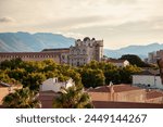 Palermo, Sicily, Italy. Warm sunlight baths the Norman Palace, a historical edifice in Palermo, with the rugged Sicilian mountains rising in the background