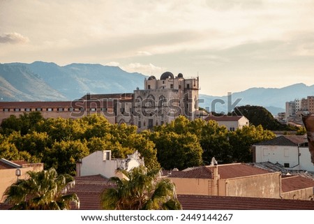 Palermo, Sicily, Italy. Warm sunlight baths the Norman Palace, a historical edifice in Palermo, with the rugged Sicilian mountains rising in the background