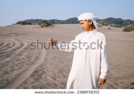 Palestine boy holding the sand at sand dunes