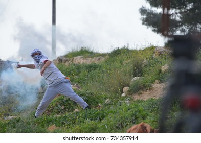 Palestinian Protester Throws A Tear Gas Cannister In Nabi Saleh Palestine, West Bank, Israel. September 2016