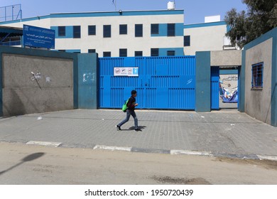 Palestinians passes in front of a closed school run by the UN Relief and Works Agency (UNRWA), in Gaza Strip. Amid new measures to counter the spread of COVID-19 coronavirus, on April 6, 2021.