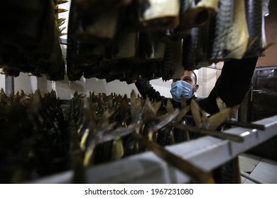 Palestinians prepare smoked fish (ranges) to be marketed in market, to celebrate the advent of the blessed Eid al-Fitr that comes after the end of Muslim month of Ramadan, in Gaza Strip on May 3, 2021
