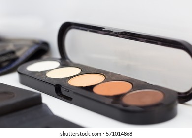 Palette of concealer and correctors for make-up base. Make-up table in beauty salon. Close up. Selective focus.