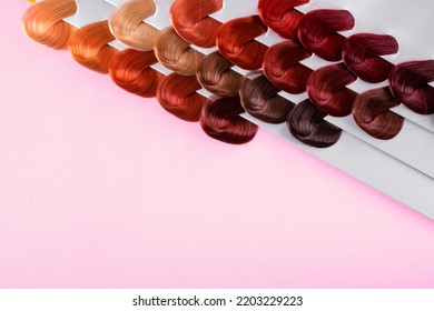 Palette With Hair Dye Swatches Of Different Colors On Pink Background. Dyeing Hair Into Assorted Shades At Hairdresser. Mockup With Copy Space