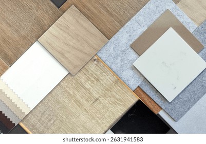palette of interior material samples including wooden ceramic tiles, wood laminate flooring tile, solid acrylics, drapery fabric, stone tiles, artificial stones in top view.