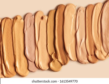 Palette of make-up foundation for different skin colors on nude background